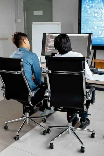 A modern workspace featuring dual computer monitors displaying web design projects, emphasizing technology and productivity.