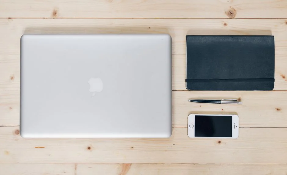 Un bureau élégant et épuré mettant en scène des appareils Apple : iMac, MacBook et iPad.